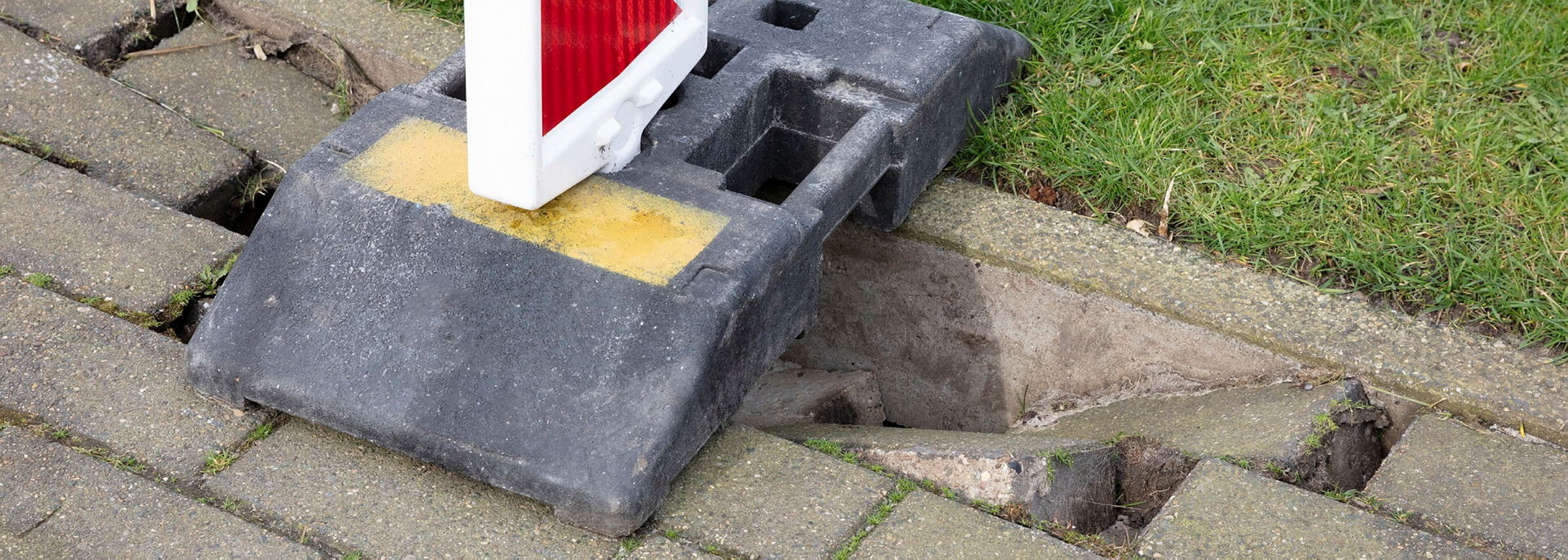 Verzonken tegel in het trottoir met markering.