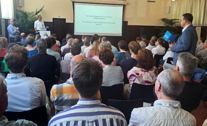 Deelnemers kijkend naar een presentatie op het congres duurzame mobiliteit