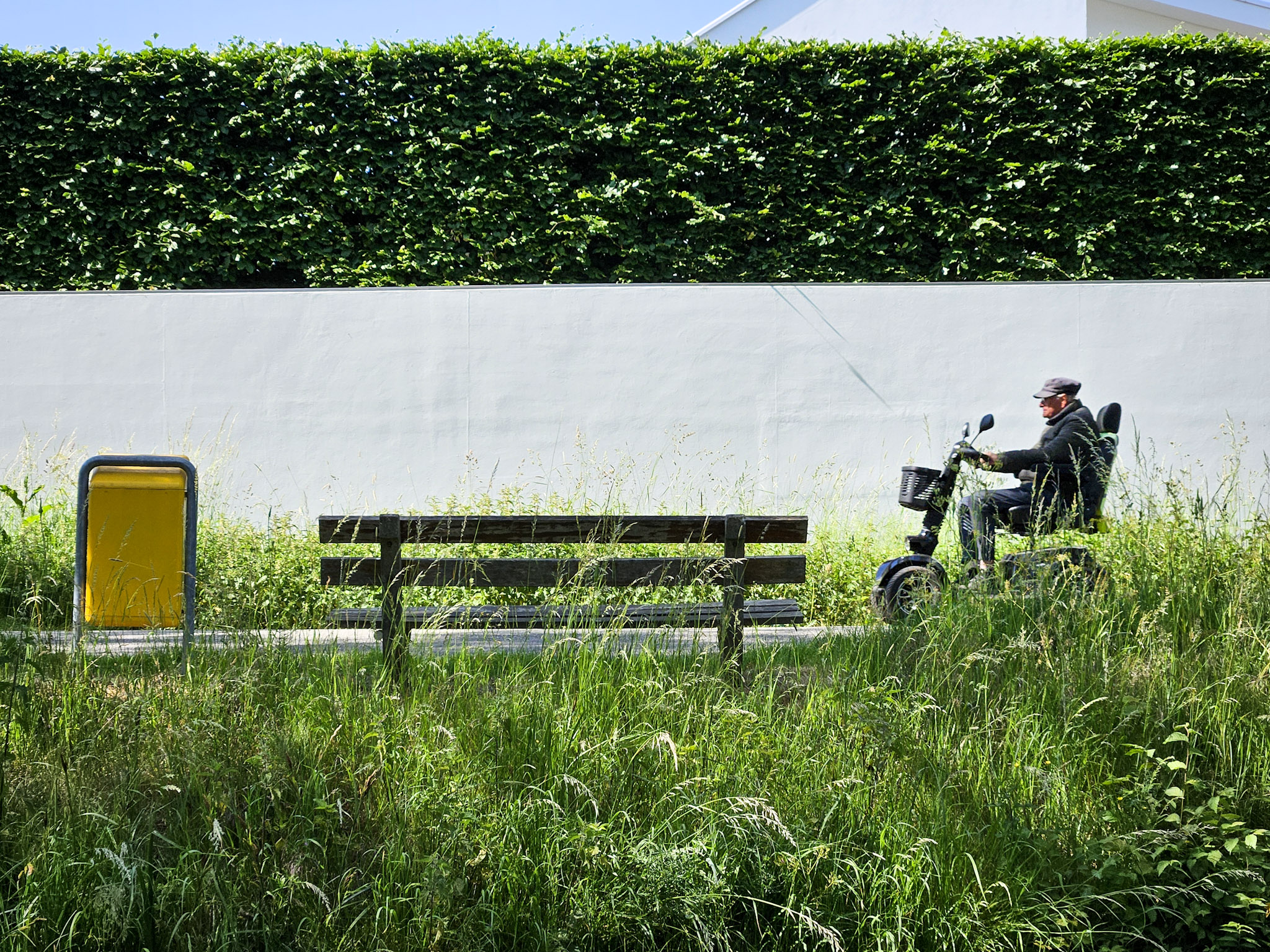 Fietspad met groen, bankje en invalide voertuig